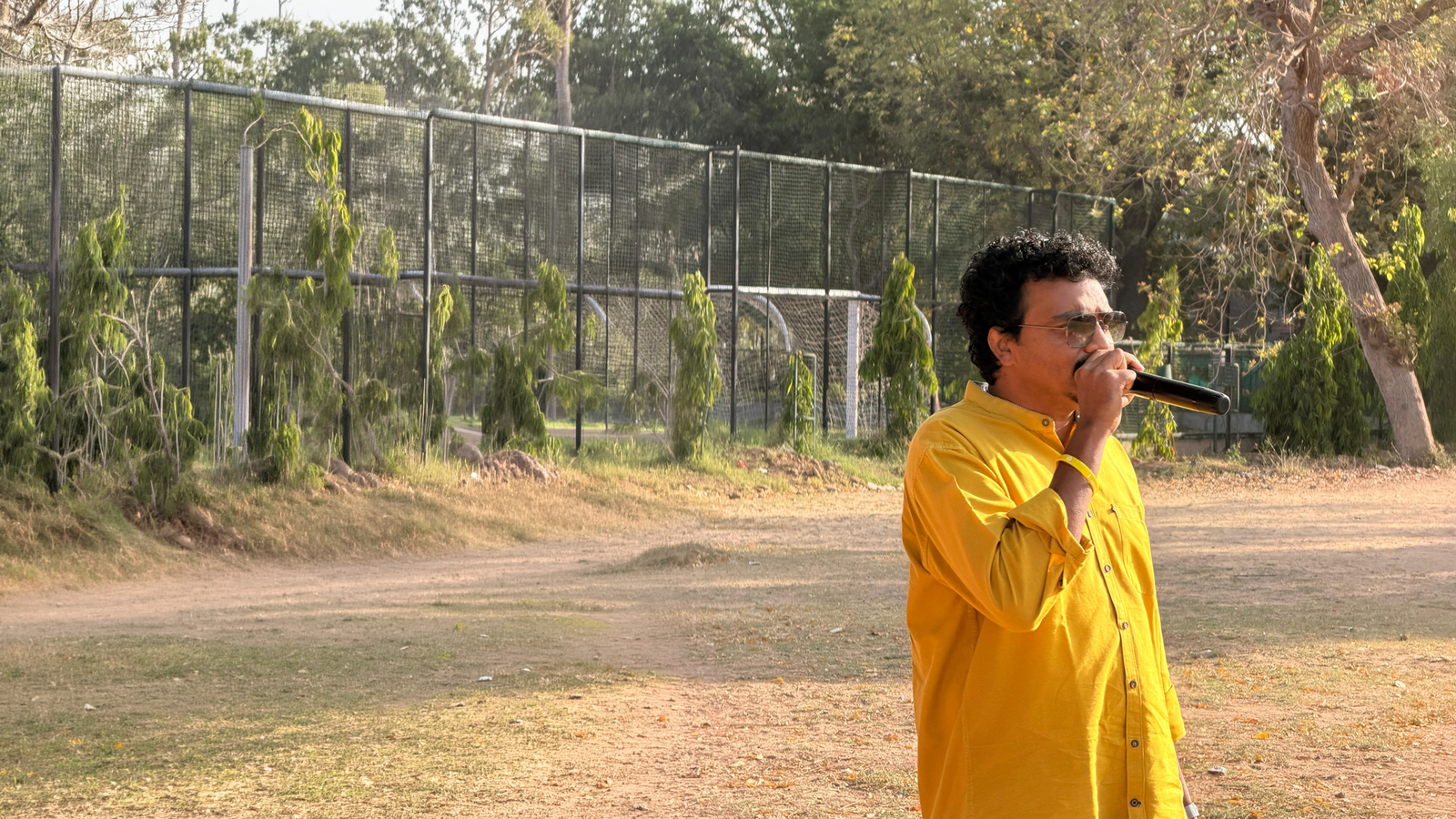 Joseph John on the mic at a cricket ground
